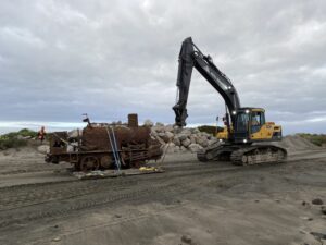 Skunk the locomotive is pulled from the South Mole by an excavator.